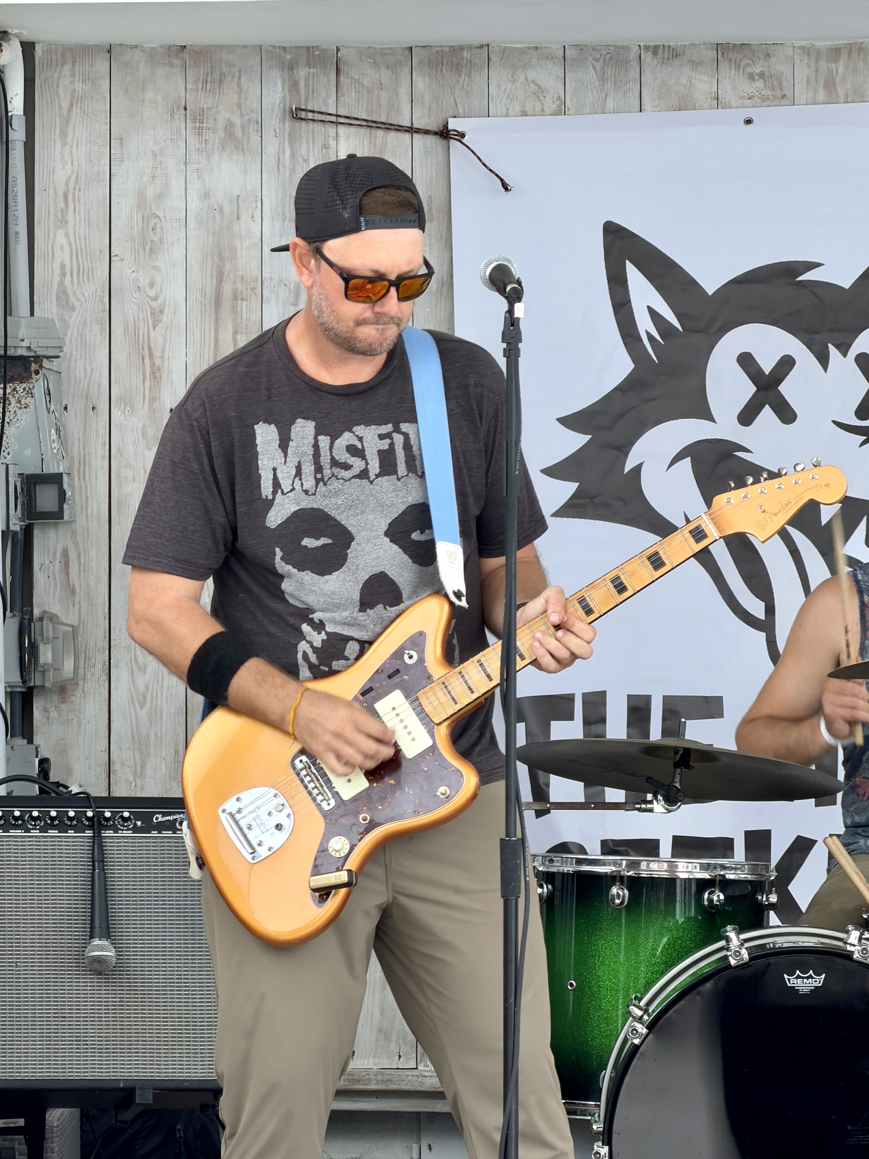 Heat Seekers guitarist Steve playing Fender Jazzmaster next to band banner at Sapphire Beach Bar St Thomas